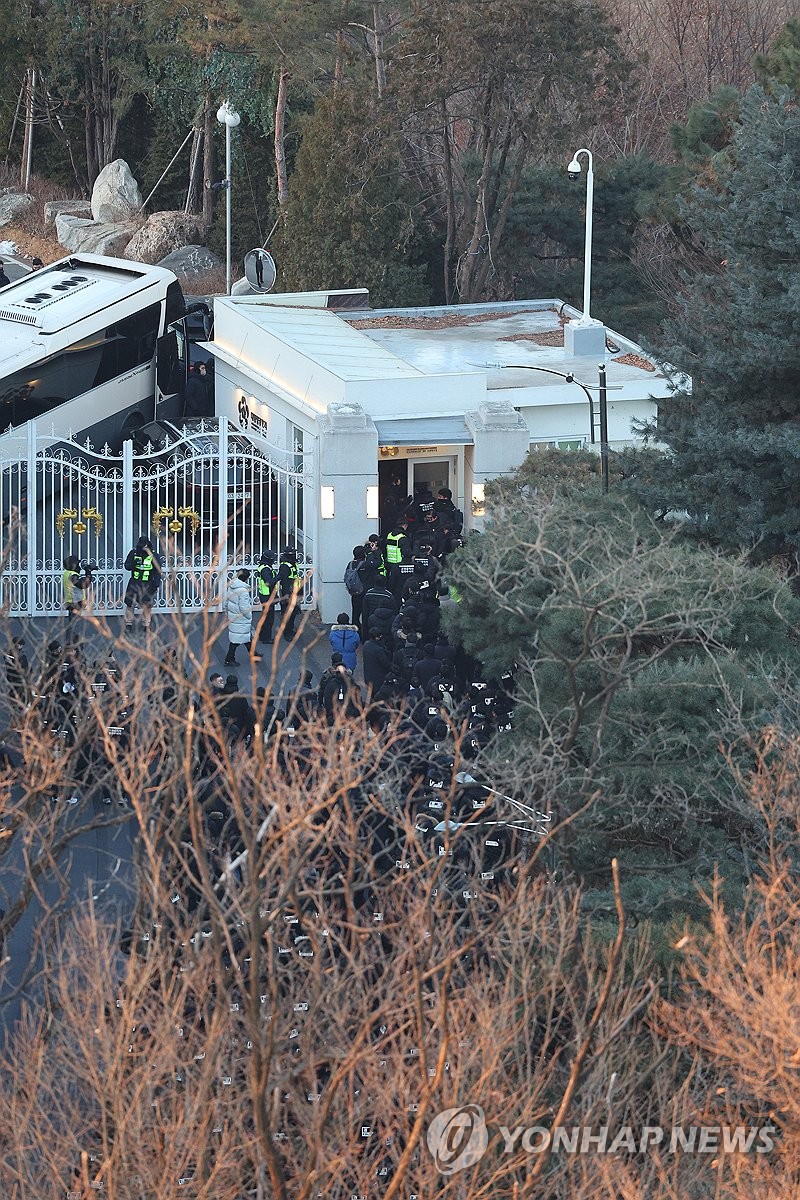 Investigators from police and the anti-corruption agency arrive at the sentry post of impeached President Yoon Suk Yeol's official residence in Seoul on Jan. 15, 2025, after they began their second attempt to execute a warrant to detain Yoon in connection to his short-lived imposition of martial law. (Yonhap)