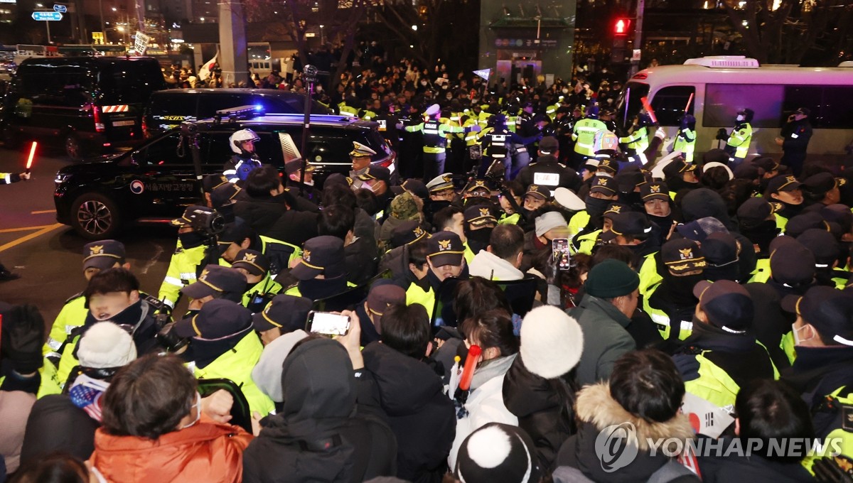 Los partidarios del presidente acusado Yoon Suk Yeol se pelean con agentes de policía en un lugar cerca del Tribunal del Distrito Occidental de Seúl, el 18 de enero de 2025. (Foto de la piscina) (Yonhap)