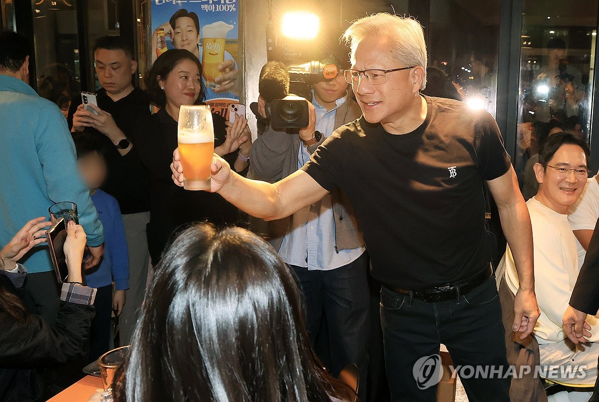Nvidia Chief Executive Officer Jensen Huang raises a glass at a fried chicken franchise in southern Seoul on Oct. 30, 2025. (Pool photo) (Yonhap)